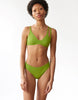 woman wearing green bikini top with asymmetric straps and matching bottoms