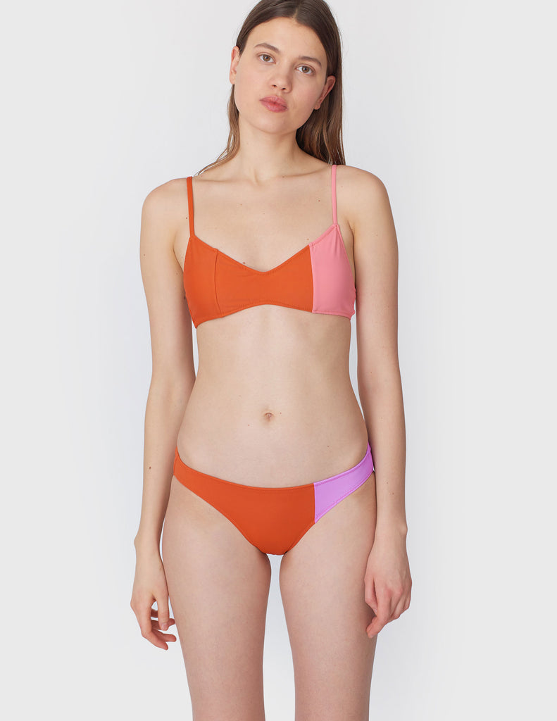 Front view of woman wearing an orange and pink bikini top with matching bikini bottom
