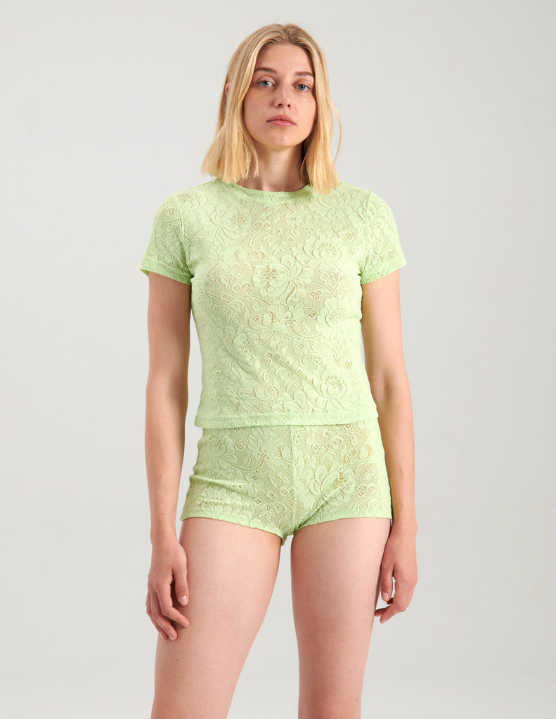 A woman wearing green lace t-shirt and shorts by Araks