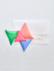 Sleep sachets (green, pink, orange, blue) next to white pouch