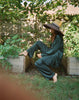 Woman in garden wearing green satin pajamas 