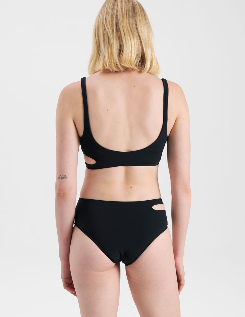 back of Woman in black bikini with cutouts