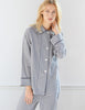 Woman wearing Blue and white gingham silk long sleeve pajama top with silk chiffon piping and a chest pocket with matching pajama pants.