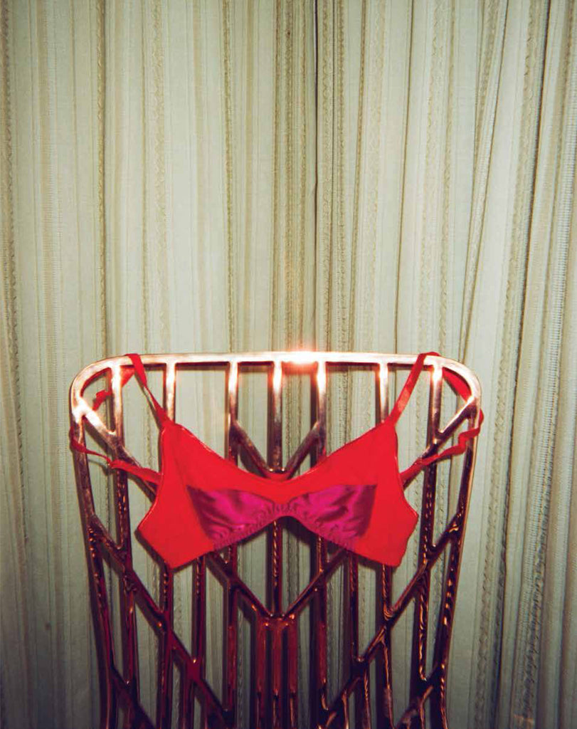 Red and magenta bralette hung on a chair.