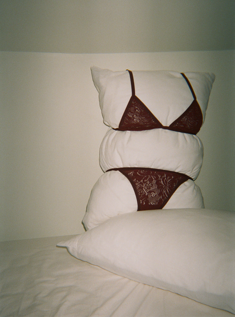 Dark red lace bra and panty on pillow