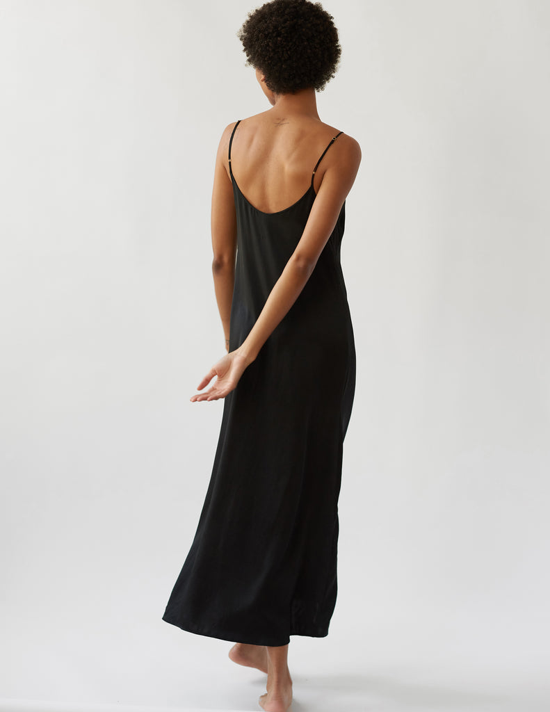 Backside of woman in long black silk slip