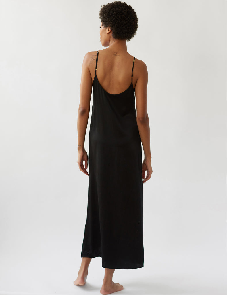 Backside of woman in long black slip dress