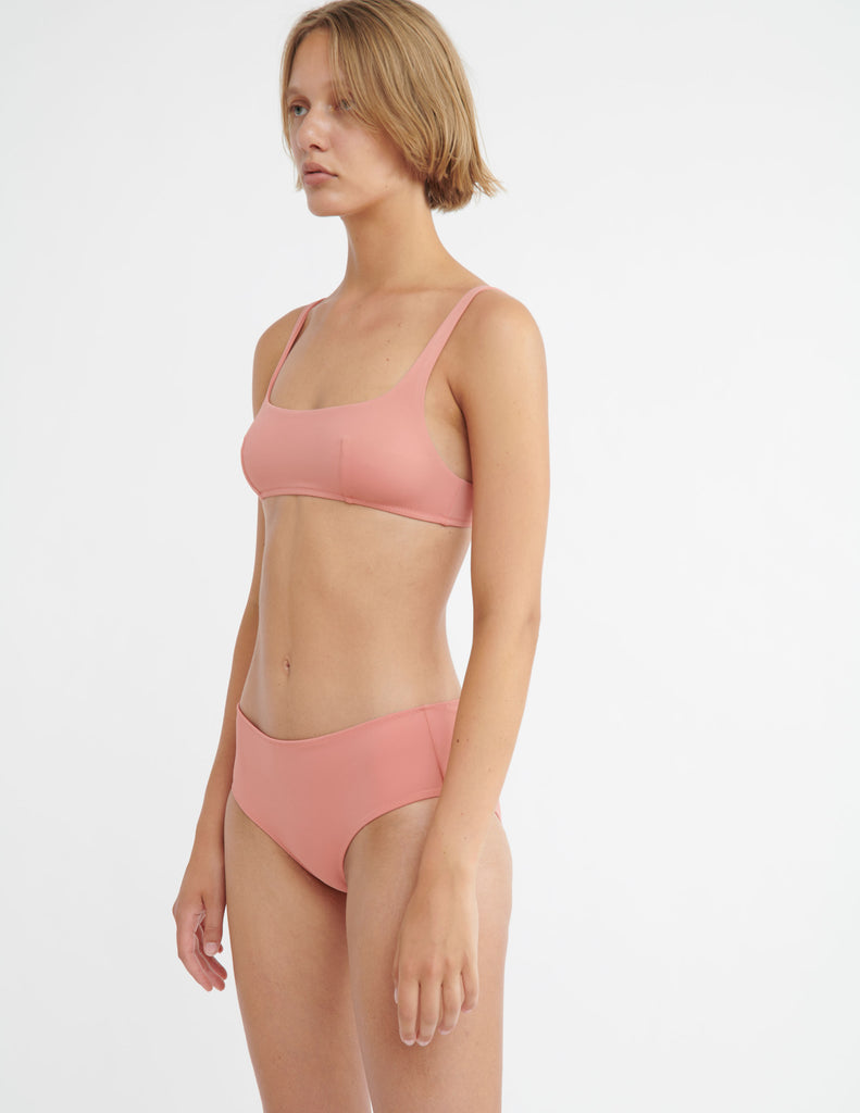 Side view image of model wearing pink bikini