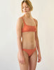 three quarter of orange bikini top and bottom on model