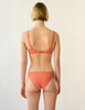 back view of woman in orange bikini top and bottom