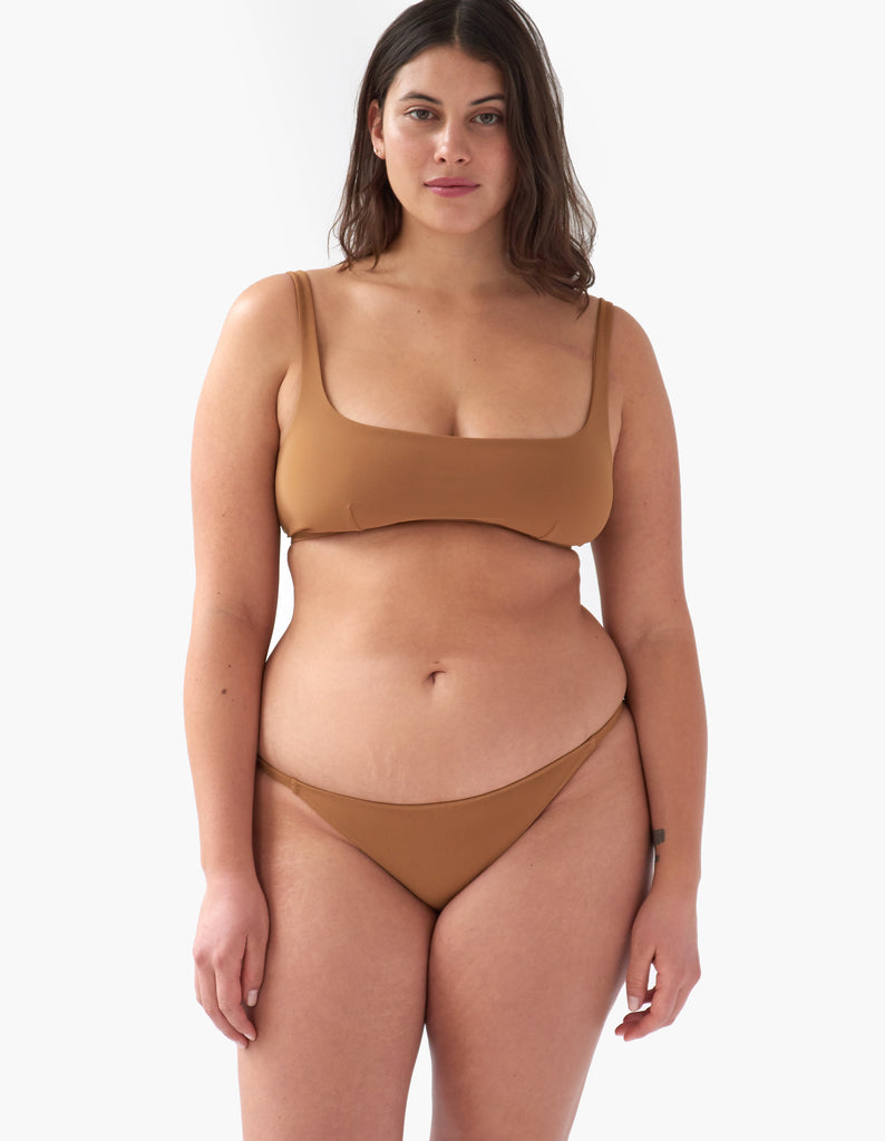 Front view of woman wearing a light brown bikini bottom with matching light brown bikini top