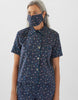 woman wearing navy floral pajama top and matching shorts and face mask