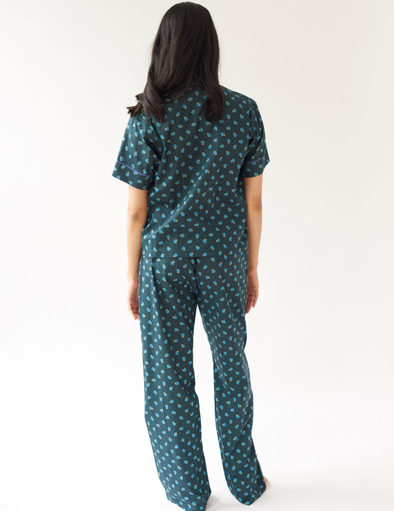 back of woman wearing green cotton pajama top with blue trim and polka dot print and matching pants by Araks