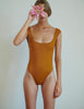 woman wearing brown one piece swimsuit by Araks
