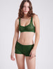 three quarter view of woman wearing green lace bra and short