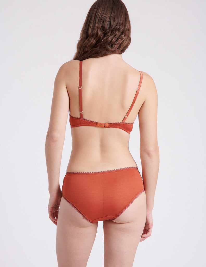 back view of woman in orange bra and panty