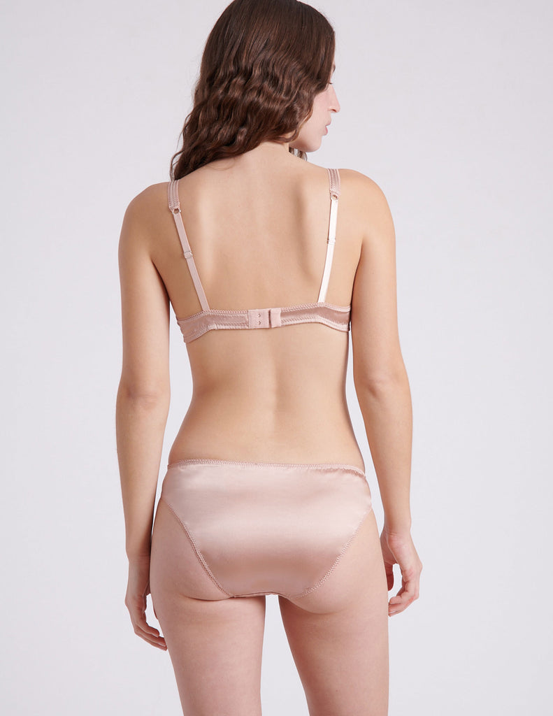 back view of woman wearing nude silk bra and panty