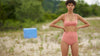 Woman stands in the field, wearing pink bralette and matching high-waisted panty