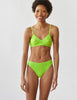 Woman wearing the green lace bralette and  panty by Araks