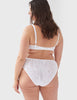Back view of woman wearing white lace panty with matching bralette