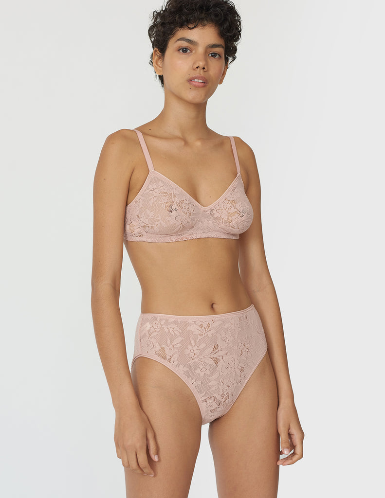 Front view of woman wearing beige lace panty with matching bralette