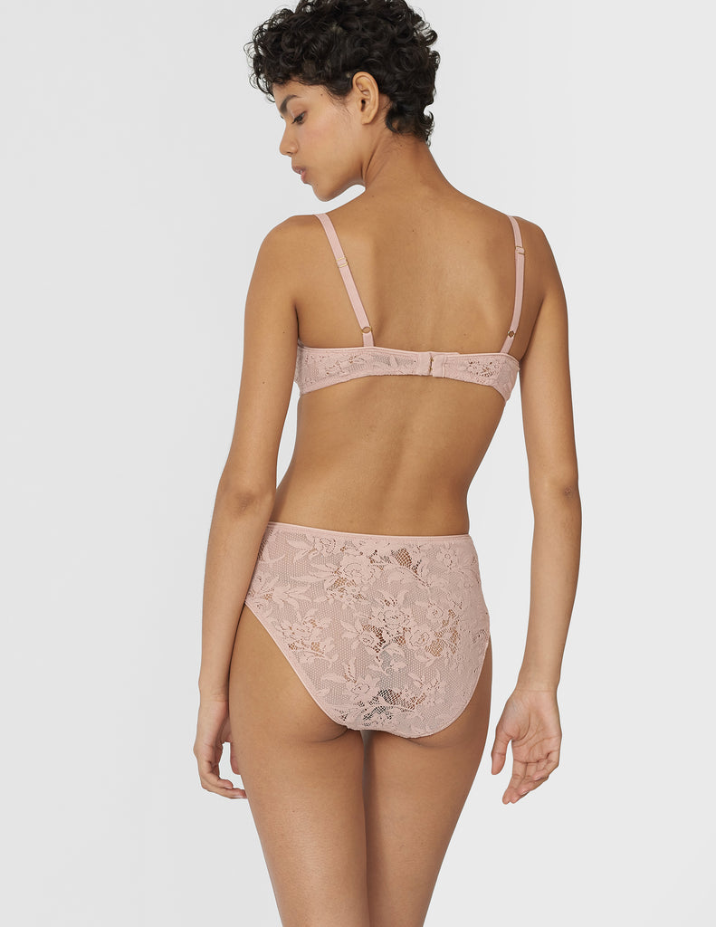 Back view of woman wearing beige lace panty with matching bralette