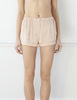 Woman wearing nude silk boxer shorts with contrast piping 