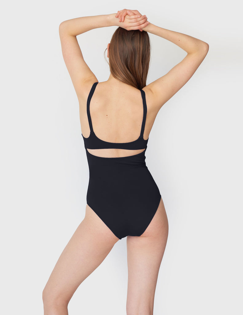 Woman wearing one piece swimsuit with back cut out