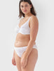 Woman wearing white, lace mid-rise panty with matching underwire bralette.