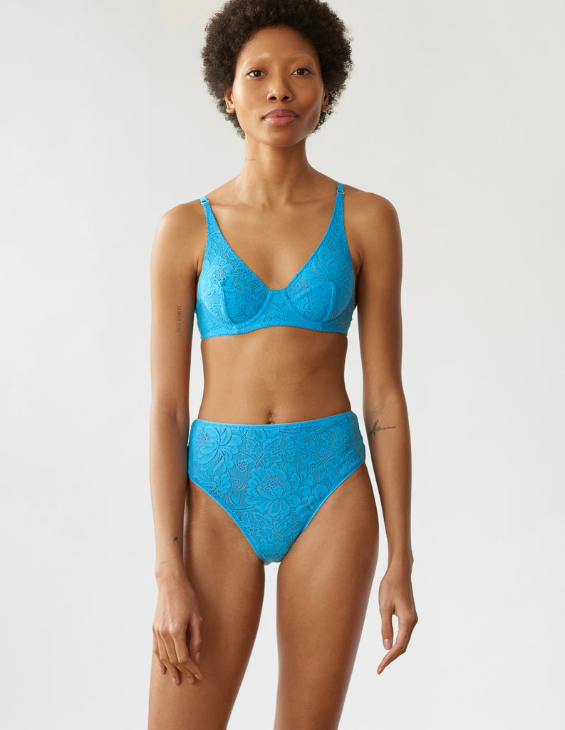Woman wearing the blue lace Waverly Underwire Bralette and Tali  lace panty.
