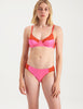Woman wearing pink and red cotton and silk bralette with matching panty by Araks