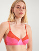 Closeup of woman wearing pink and red cotton and silk bralette