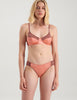 Woman wearing orange and brown cotton and silk bralette with matching panty by Araks