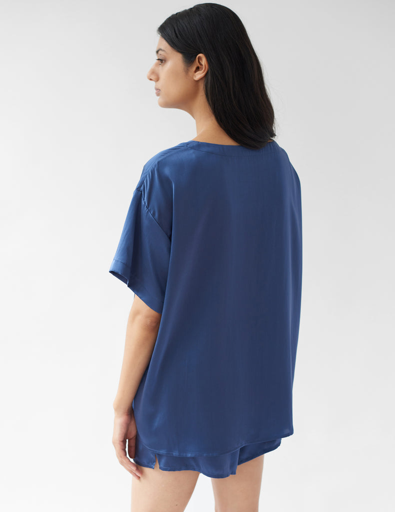 back of woman wearing blue silk t-shirt and matching shorts by Araks