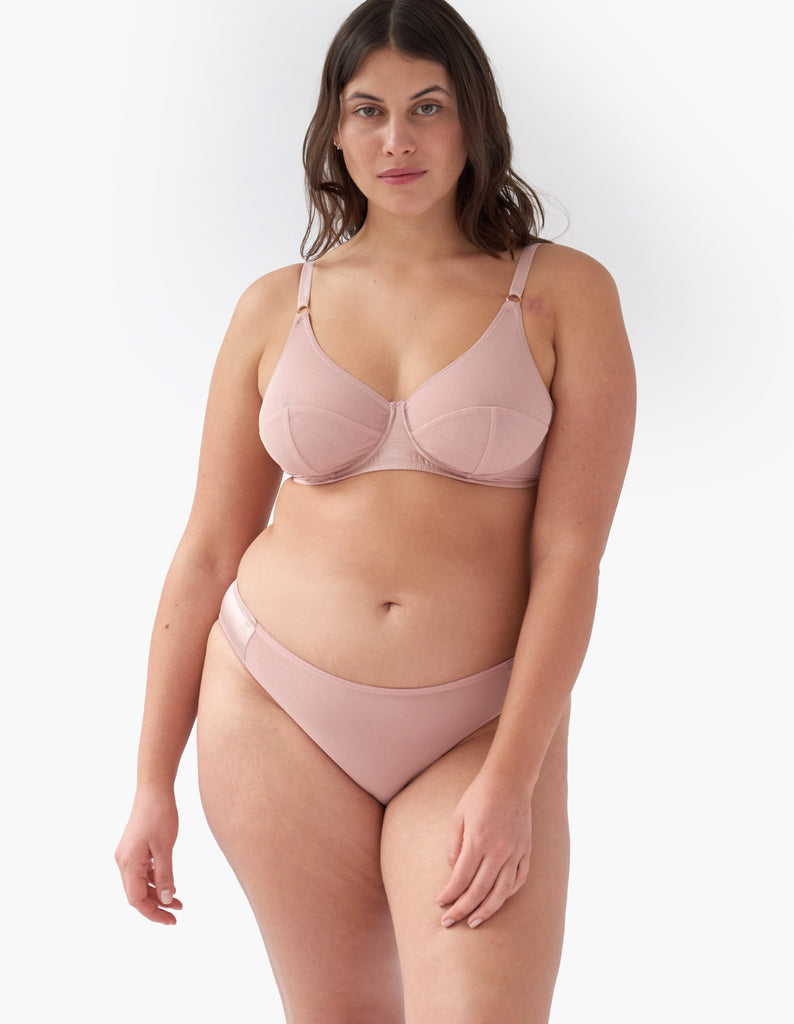 Front view of woman wears beige mesh underwire bra and matching panty. 