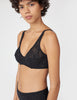 Three quarter view of woman wearing black, lace underwire bra and matching mid-rise panty.