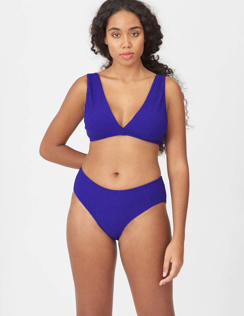 Front view of woman wearing a blue bikini bottom with matching blue bikini top