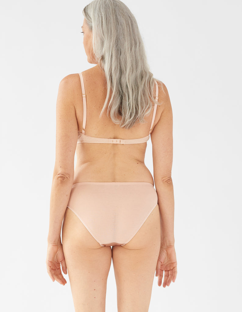 back of woman wearing beige  bra and matching panty