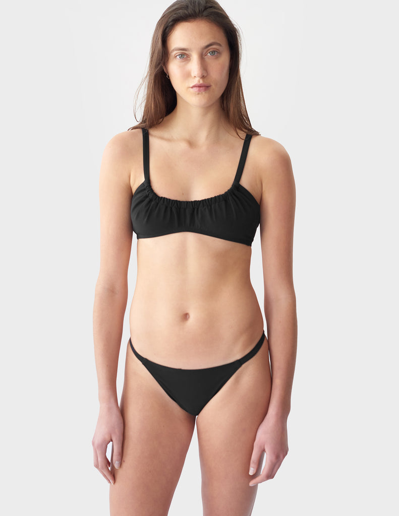 Front view of woman wearing a black bikini top with matching bikini bottom
