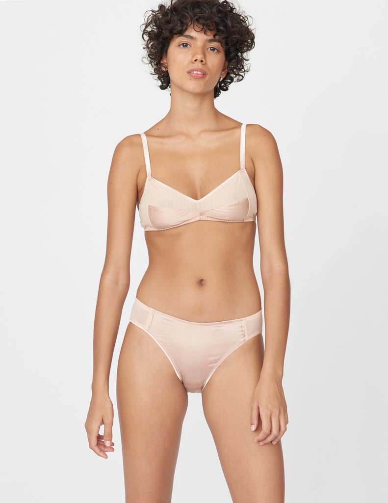 Front view of model wearing beige bralette and matching panty. 