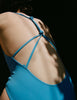 woman in blue one piece with knotted back by Araks