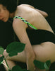 woman wearing black one piece with green, white, blue and black braided straps
