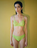 Woman wearing the green lace bralette and  panty by Araks