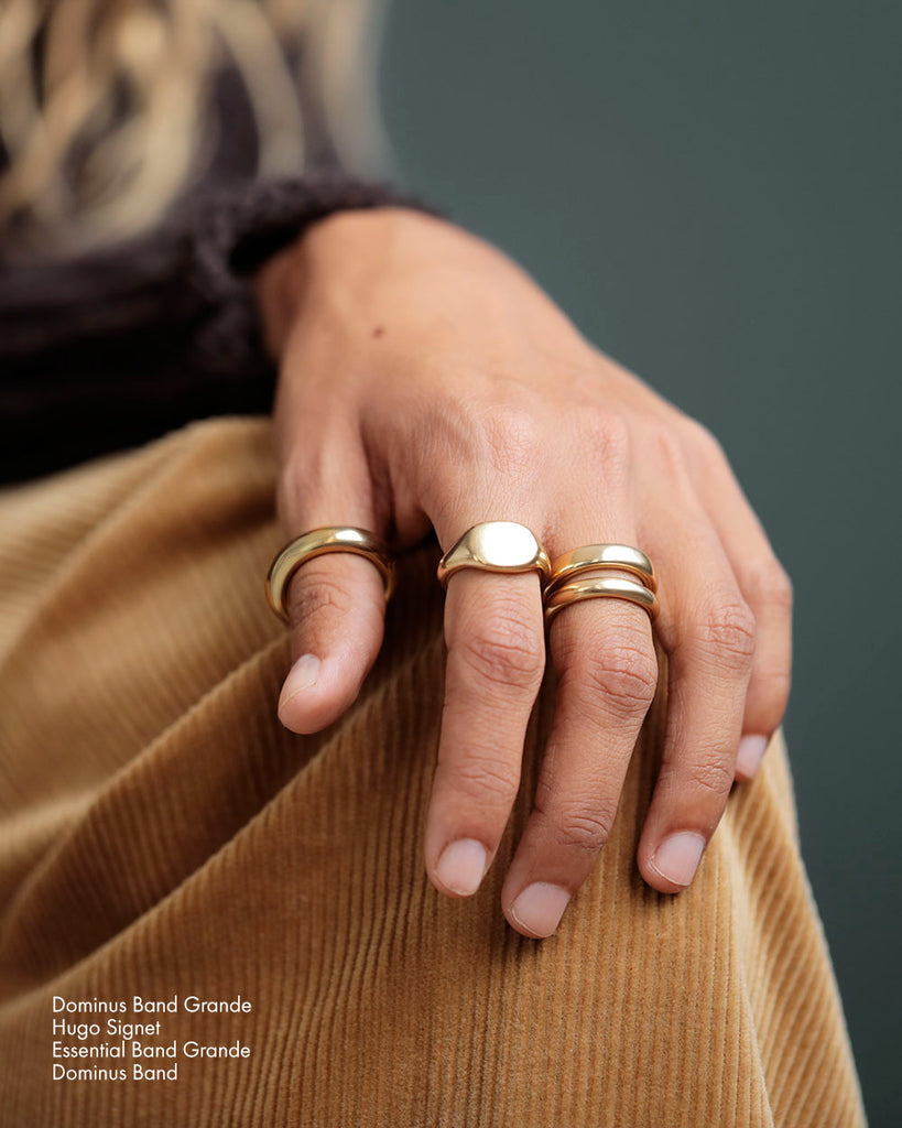 Young white woman wears Large 18k solid yellow gold donut ring on her middle finger.