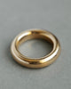 Large 18k solid yellow gold donut ring on gray paper
