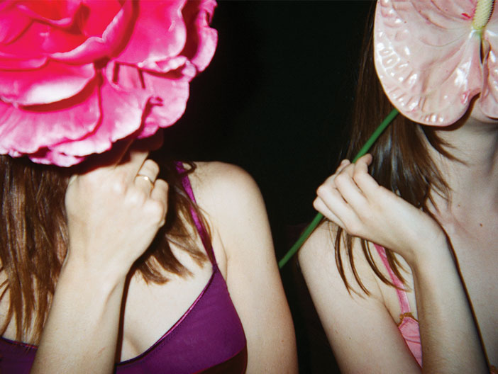 Woman with flowers covering face